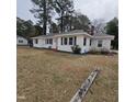 Charming single-story home with white siding and dark shutters, set on a spacious lot with mature trees at 1309 Eastern Avenue Ave, Rocky Mount, NC 27801