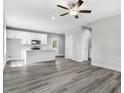 Open concept kitchen with island, white cabinets, and gray vinyl plank flooring at 157 Rainbow Dr, Dunn, NC 28334