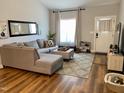 Open living room with L-shaped sectional and wood floors at 26 Wildberry Ct, Rocky Mount, NC 27804