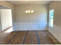 Bright dining room features modern lighting, wainscoting and hardwood flooring ready to be uncovered at 260 Olivia Crossing Ct # 9, Four Oaks, NC 27524