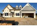 New construction home featuring a two-car garage, dormer windows and gray siding on a clear, sunny day at 260 Olivia Crossing Ct # 9, Four Oaks, NC 27524