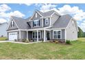 Traditional home exterior featuring a manicured lawn, stone accents, and gray siding at 467 Ravensworth Dr, Garner, NC 27529