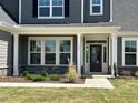 Inviting front entrance with stone accents, manicured landscaping, and craftsman-style door at 467 Ravensworth Dr, Garner, NC 27529