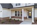 Front entrance with a dark door, brick columns, and white trim at 467 Ravensworth Dr, Garner, NC 27529