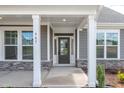 Covered porch featuring stone accents, white pillars and a modern front door at 467 Ravensworth Dr, Garner, NC 27529