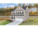 Two-story house with gray siding, white garage door, and landscaping in wooded area at 505 Ravensworth Dr, Garner, NC 27529