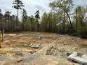 New home foundation with block and gravel ready for construction in wooded area at 68 Streamline Ct, Lillington, NC 27546