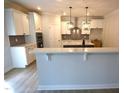 Modern kitchen featuring white cabinets, quartz countertops, stainless steel appliances, and pendant lighting at 70 Accord Dr, Youngsville, NC 27596