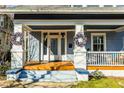 Inviting front porch with wooden flooring, wreaths, and seating at 807 E Edenton St, Raleigh, NC 27601