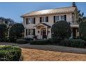 Two-story white brick home with black shutters, landscaping, and a stone pathway at 921 Vance, Raleigh, NC 27608