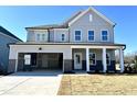 Two-story home with gray siding, brick accents, and a two-car garage at 100 S Stone Mill E Trl # 234, Clayton, NC 27520