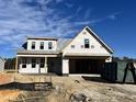 New home under construction showcases a front porch, two-car garage, and classic architectural style at 107 Pretty Run Branch Ln, Wendell, NC 27591