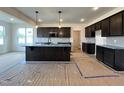 Spacious kitchen with dark cabinetry, stainless steel appliances, and a large island with pendant lighting at 107 Pretty Run Branch Ln, Wendell, NC 27591