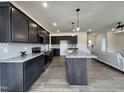 Beautiful kitchen with dark wood cabinets, granite counters, stainless appliances, and an open living area at 107 Pretty Run Branch Ln, Wendell, NC 27591