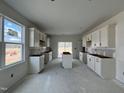 Bright kitchen featuring white cabinets, a center island, and a large window for natural light at 137 Pretty Run Branch Ln, Wendell, NC 27591