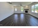 Spacious living room with a ceiling fan, fireplace, and large windows providing ample natural light at 137 Pretty Run Branch Ln, Wendell, NC 27591