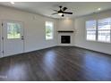 Bright living room featuring wood flooring, a ceiling fan, and a modern fireplace with mantle at 137 Pretty Run Branch Ln, Wendell, NC 27591