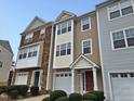 Three-story townhome with stone and siding, two-car garage, and landscaping at 1527 Haywards Heath Ln, Apex, NC 27502
