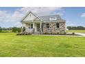 Attractive home with stone accents, a cozy porch, and a well-maintained lawn at 292 Weddington Way, Benson, NC 27504