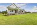 Well-kept home with stone and siding details, a front porch, and a green lawn at 292 Weddington Way, Benson, NC 27504