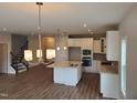 Bright kitchen showcasing white cabinetry, stainless steel appliances, and a center island with seating at 308 Whispering Way, Sanford, NC 27330
