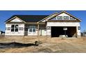 New construction home exterior; brick, vinyl siding, and a two-car garage at 313 Springtooth Dr, Zebulon, NC 27597