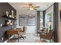Modern home office with a desk, two armchairs, and built-in shelving at 3391 Mission Olive Pl, New Hill, NC 27562