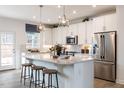 Modern kitchen with white cabinets, large island, stainless steel appliances, and an eat-in area at 3391 Mission Olive Pl, New Hill, NC 27562