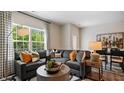 Spacious living room featuring a sectional sofa and large windows at 448 Belgian Red Way, Wake Forest, NC 27587