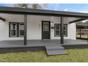 House exterior showcasing a welcoming front porch with gray flooring and black support beams at 521 Mill St, Smithfield, NC 27577