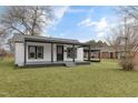 White house with a covered porch, black accents, and a grassy yard at 521 Mill St, Smithfield, NC 27577