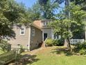 Cozy home exterior featuring neutral siding, a black front door, and lush landscaping at 5718 Sentinel Dr, Raleigh, NC 27609