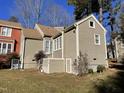 Rear view of house with tan siding, landscaping, and a storage unit at 5718 Sentinel Dr, Raleigh, NC 27609