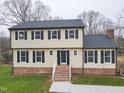 Two-story house with brick and siding, featuring a front porch and landscaped lawn at 802 S Sellars Mill Rd, Burlington, NC 27217