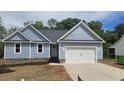 Charming single-story home with light blue siding, black roof, and a two car attached garage at 121 Tanglewood Dr # 8-J, Louisburg, NC 27549
