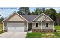 Charming single-story home with green siding, black roof, and a two car attached garage at 121 Tanglewood Dr # 8-J, Louisburg, NC 27549