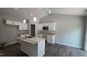 Bright kitchen featuring white cabinets, modern appliances, and a stylish island with granite countertops at 121 Tanglewood Dr # 8-J, Louisburg, NC 27549