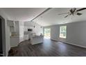 Bright, open-concept living room featuring modern dark wood floors and a connected kitchen with an island at 121 Tanglewood Dr # 8-J, Louisburg, NC 27549