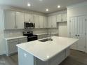 Modern kitchen with stainless steel appliances, gray cabinets, an island, and white marble backsplash at 129 Stallion Way, Benson, NC 27504