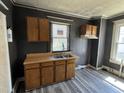 A kitchen area featuring wood cabinets, double bowl sink, and modern plank flooring at 1301 Branch St, Rocky Mount, NC 27801
