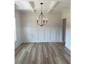 Dining room features hardwood floors, wainscoting and modern black chandelier at 145 Surles Landing Way, Benson, NC 27504