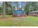 Cute brick ranch home with blue accents and a grassy yard at 1558 Harper St, Rocky Mount, NC 27801