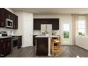 Spacious kitchen with dark brown cabinets, granite counters, and an island at 3623 Massey Pond Trl # Madison, Raleigh, NC 27616