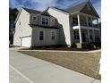 Side view of a two-story home with a two-car garage and manicured lawn at 427 Rising Star Dr, Clayton, NC 27520