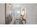 Bright entryway with a console table, mirror, and stairs leading upstairs at 442 Belgian Red Way, Wake Forest, NC 27587