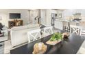 Open concept dining room with black table and white chairs, adjacent to kitchen at 508 Freedom Trail Dr, Willow Springs, NC 27592