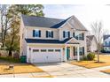 Two-story house with beige siding, black shutters, and a teal front door at 8065 Gilano Dr, Raleigh, NC 27603