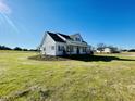 White farmhouse with covered carport and landscaping at 873 Gilbert Rd, Benson, NC 27504