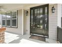 Stylish front door with sidelights, brick accents, and elegant outdoor lighting at 108 Cross Oaks Pl, Holly Springs, NC 27540