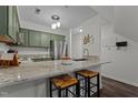Renovated kitchen with granite countertops and green cabinets at 11 Stone Village, Durham, NC 27704